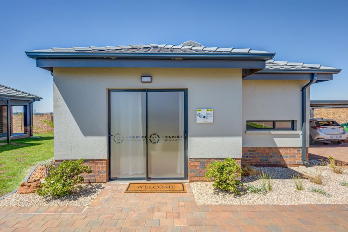 Front exterior view of a modern residential house featuring a paved entrance, sliding glass door, and tiled roof.