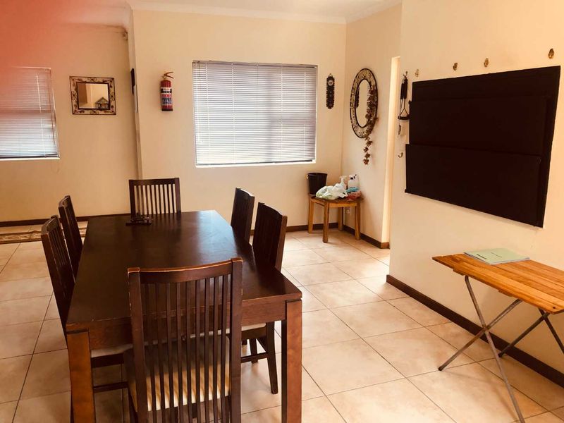 A functional dining area featuring tiled flooring and venetian blinds, providing a neutral space ready for personalization.