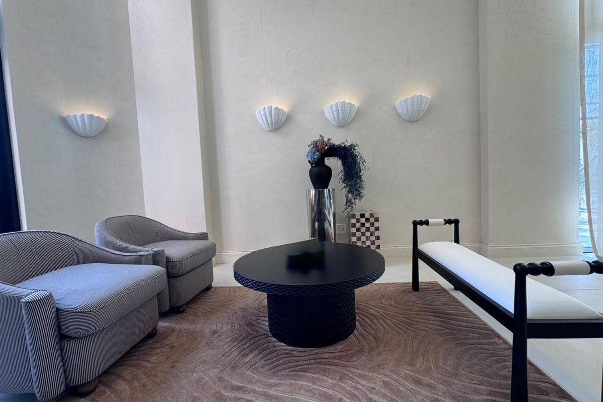A well-lit living area featuring decorative wall sconces and neutral wall finishes, creating a sophisticated and inviting atmosphere.