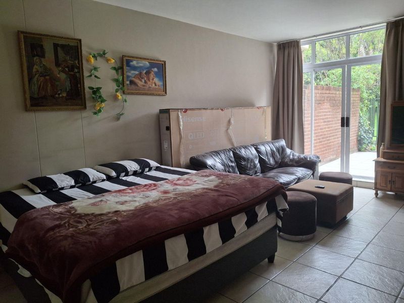 A bedroom featuring tiled flooring and a large sliding glass door providing access to an outdoor area.