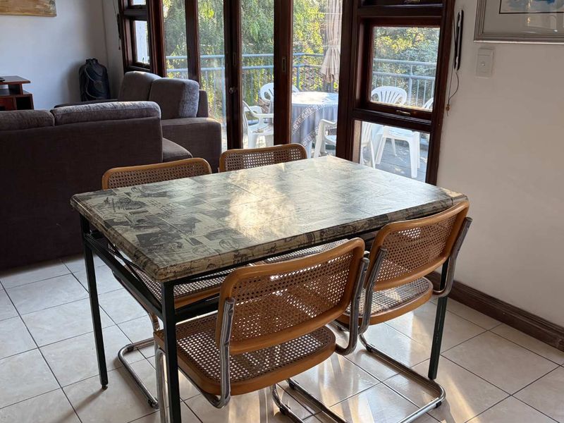 Dining area featuring tiled flooring and large timber-framed glass sliding doors that provide access to an outdoor balcony.