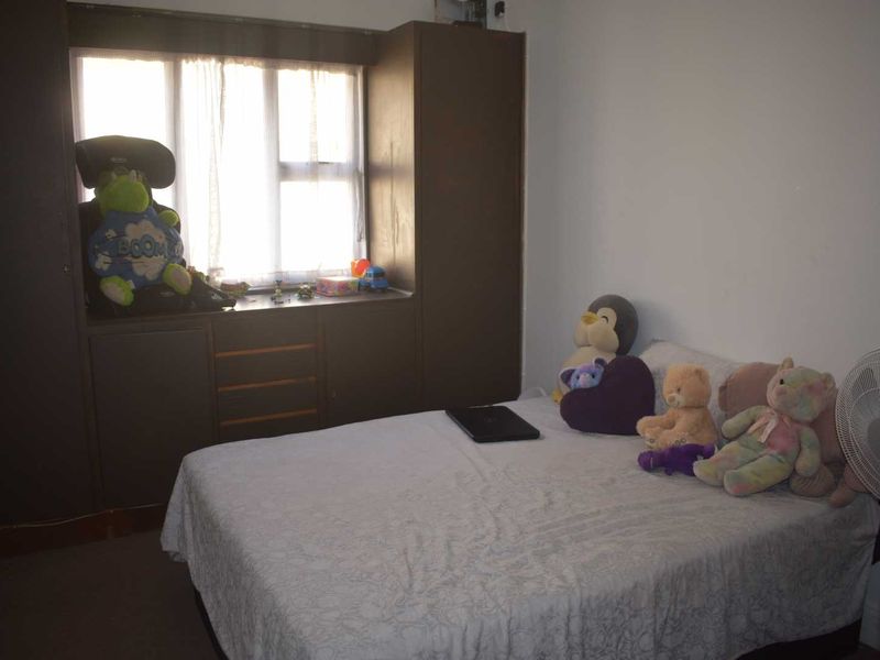 A bedroom featuring built-in cupboards and a window, providing functional storage and natural light.