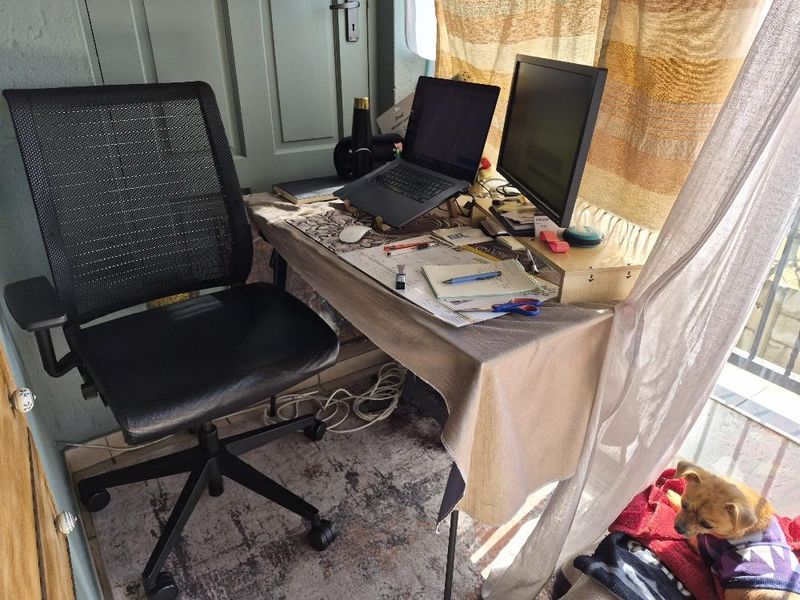 A small home office workspace featuring a desk positioned near a window and door.