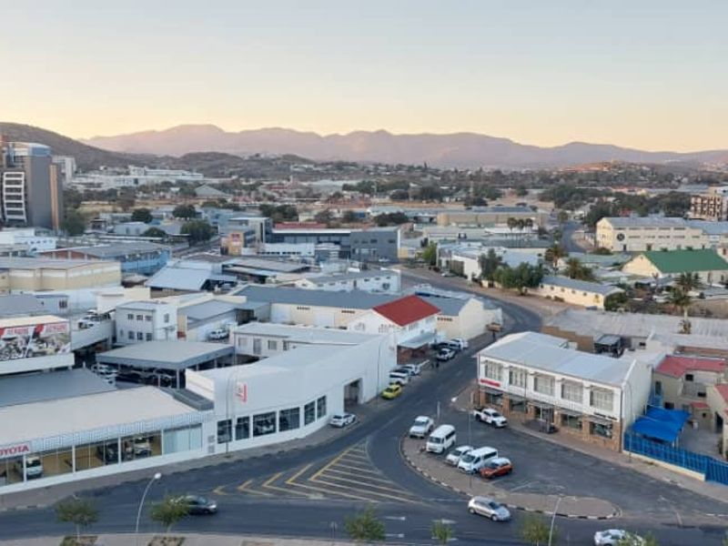 An elevated aerial view overlooking the surrounding urban landscape, commercial buildings, and distant mountain range.