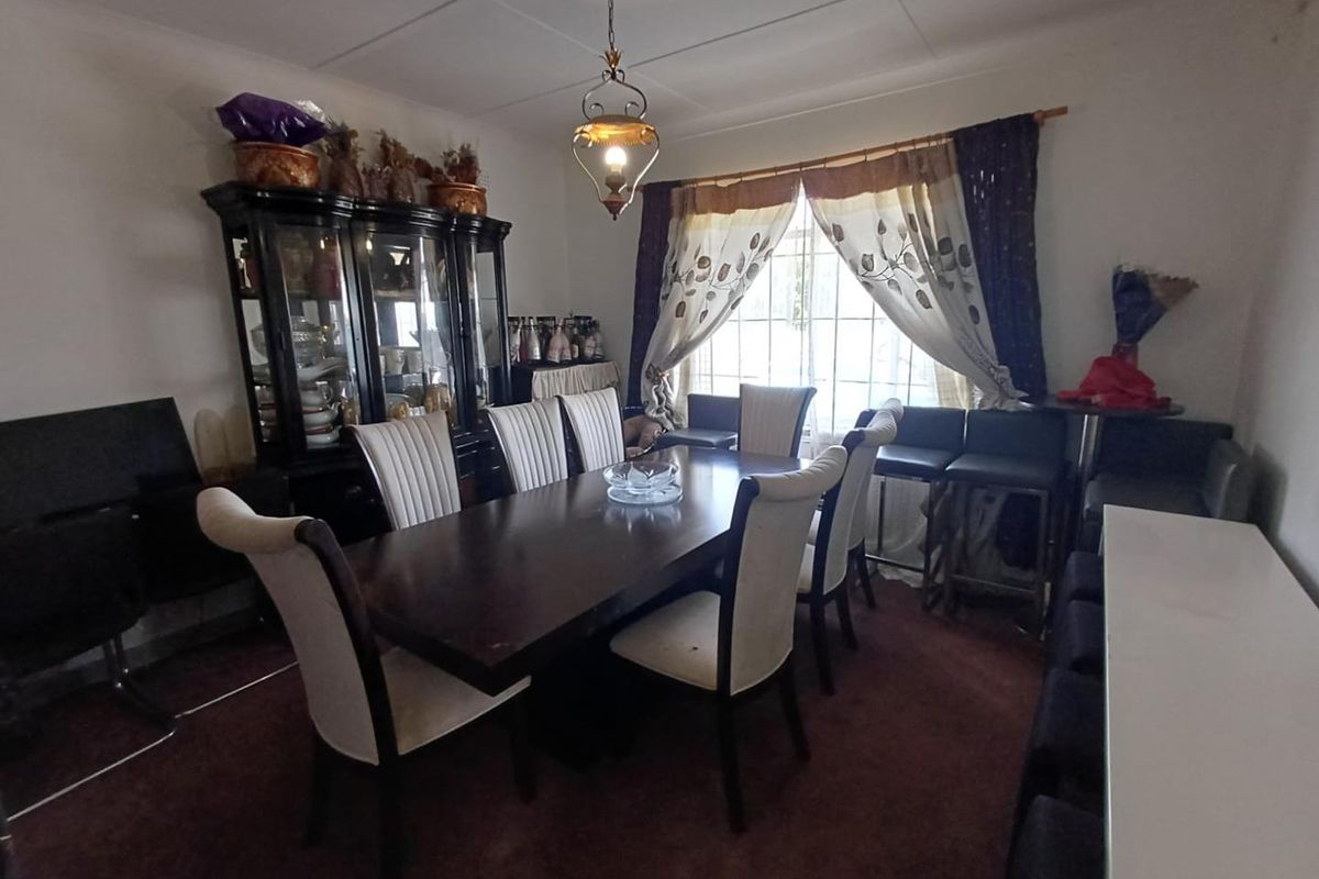 A functional dining room featuring a central pendant light fixture and large window, providing a dedicated space for family meals and entertaining.