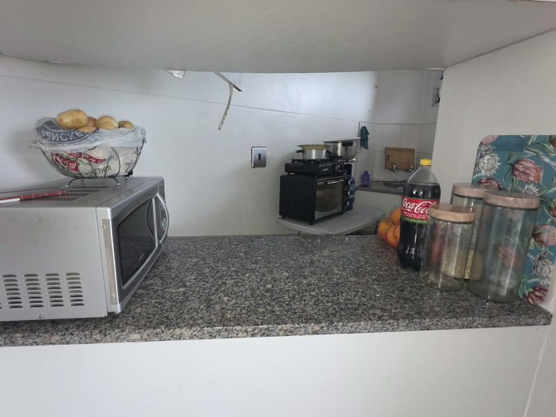 A kitchen area featuring a granite countertop and visible electrical infrastructure, currently showing signs of unfinished wall surfaces and exposed wiring.