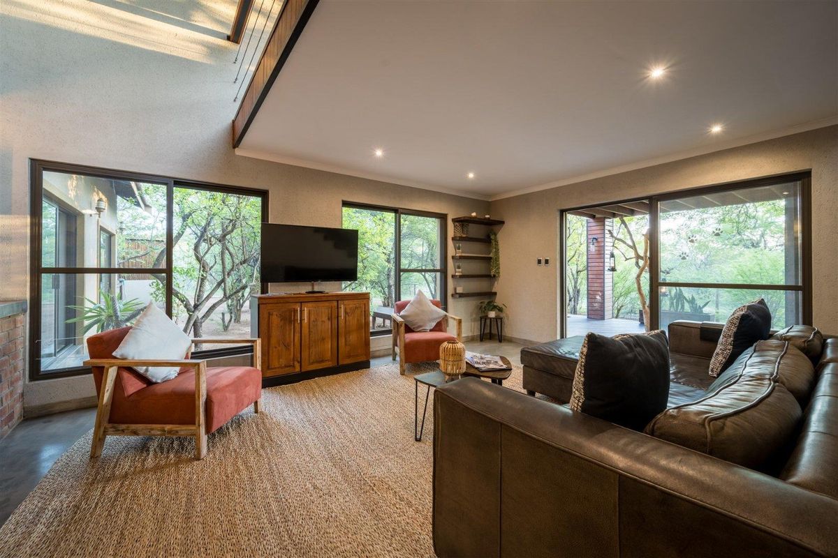 Spacious living room featuring large sliding glass doors that provide abundant natural light and views of the surrounding trees.