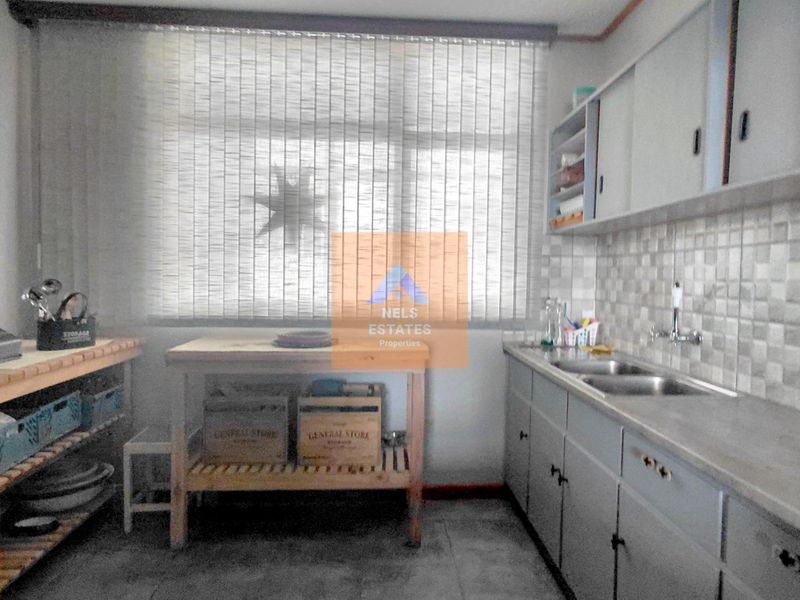 A functional kitchen space featuring built-in cabinetry, a double basin sink, and tiled backsplash, offering potential for modernization and aesthetic updates.
