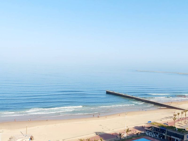 Elevated panoramic view of the coastline, beach, and ocean pier from the apartment.