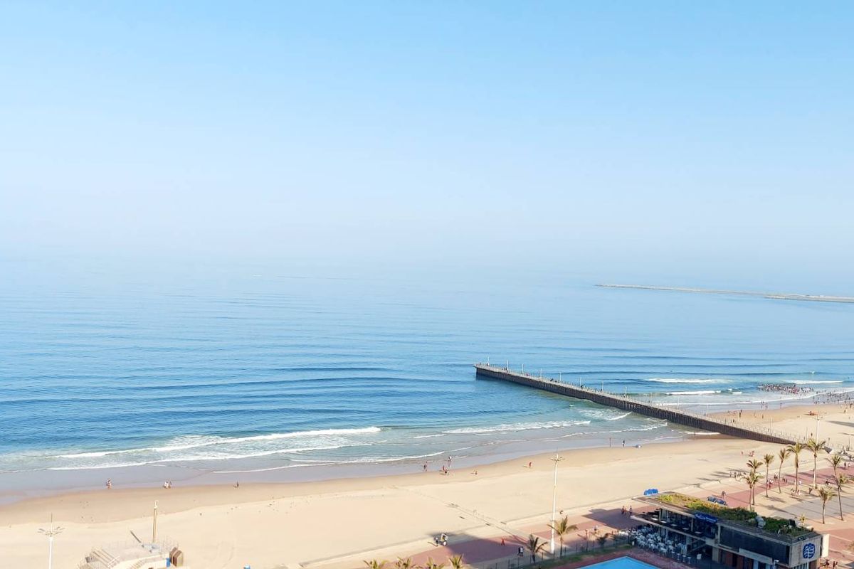 Elevated panoramic view of the coastline, beach, and ocean pier from the apartment.