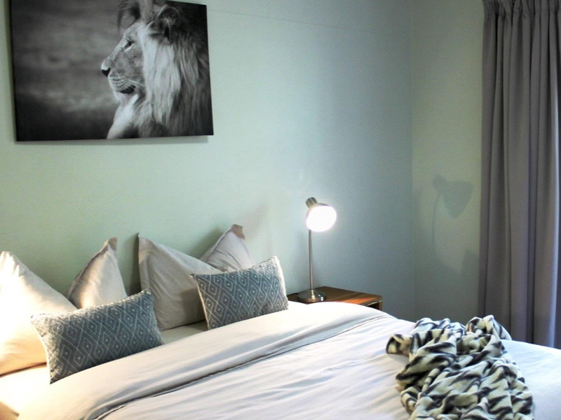 A well-maintained bedroom featuring neutral wall tones and functional window treatments.