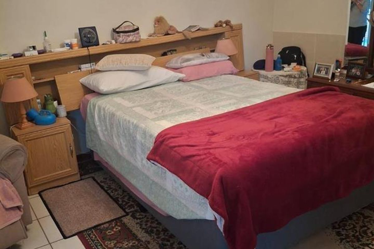 A bedroom featuring tiled flooring and a built-in headboard unit.