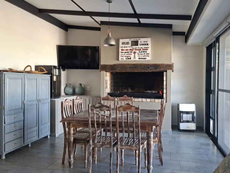 Spacious living area featuring a built-in fireplace, exposed ceiling beams, and large sliding glass doors providing access to the outdoor space.