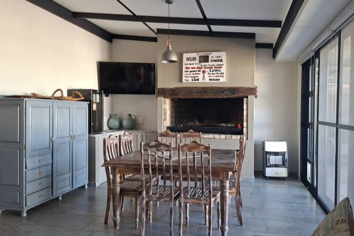 Spacious living area featuring a built-in fireplace, exposed ceiling beams, and large sliding glass doors providing access to the outdoor space.