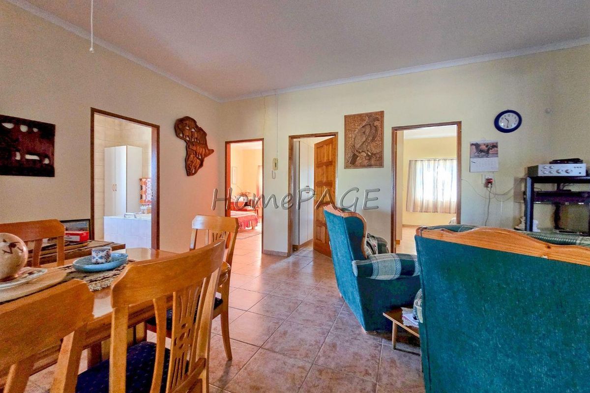 A view of the living area featuring tiled flooring and multiple doorways leading to adjacent rooms within the home.