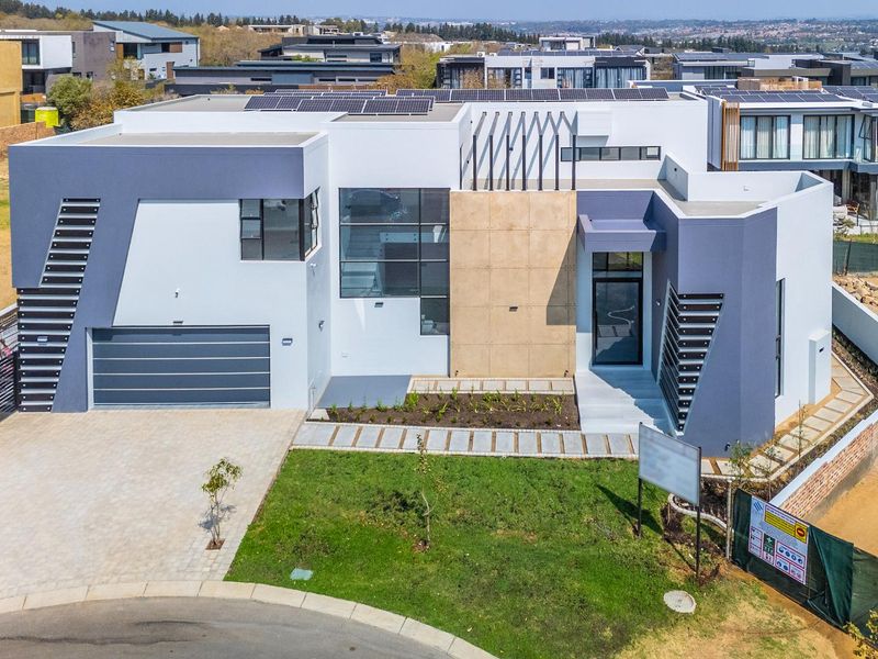 Modern contemporary double-story home featuring a striking architectural facade, integrated solar panels, a double garage, and a well-maintained front garden.