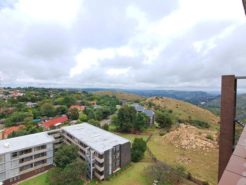 Elevated panoramic view overlooking the surrounding residential neighborhood and natural landscape from the apartment balcony.