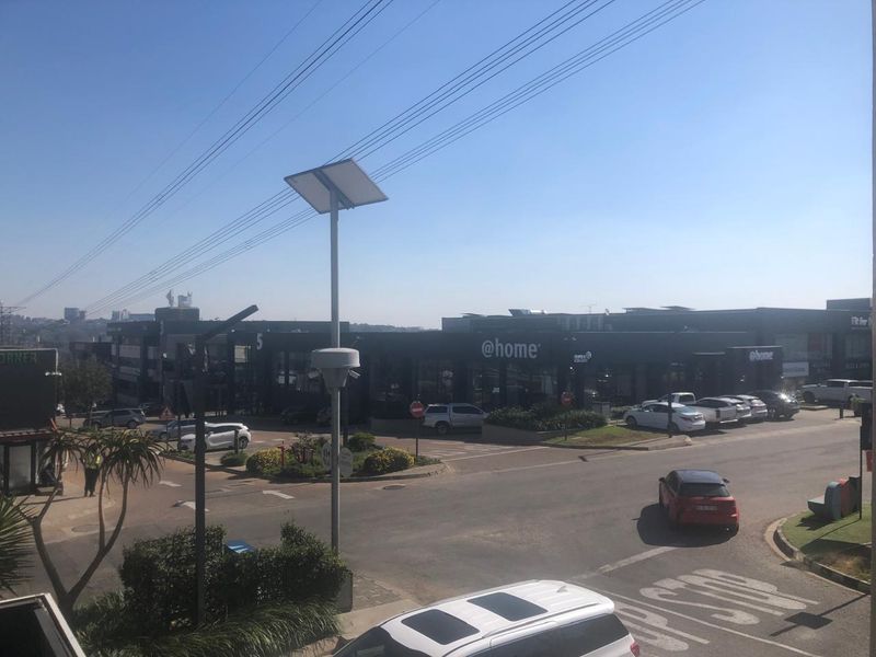 An elevated street view showing the surrounding commercial office park, parking facilities, and road infrastructure.