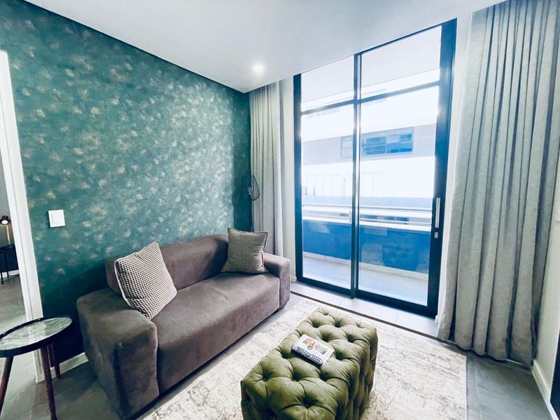 A modern living room featuring a striking textured feature wall and large floor-to-ceiling sliding glass doors that provide access to an outdoor balcony.