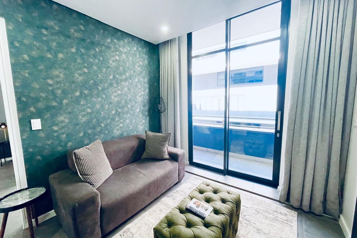 A modern living room featuring a striking textured feature wall and large floor-to-ceiling sliding glass doors that provide access to an outdoor balcony.