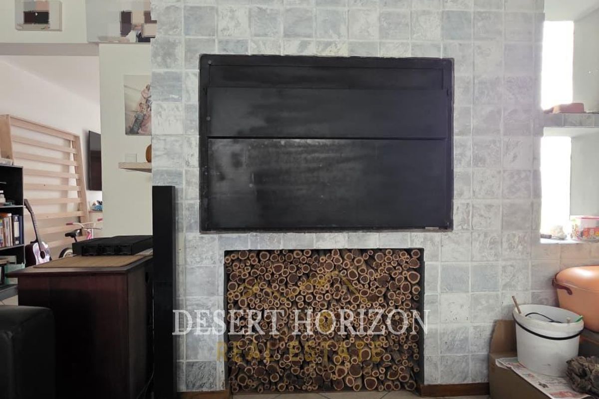 Living room featuring a prominent built-in fireplace with a tiled surround and integrated log storage compartment.