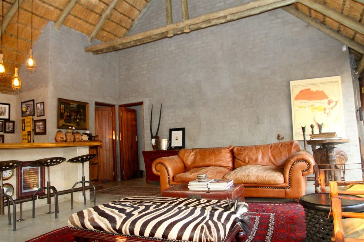 Spacious living area featuring a high vaulted thatched roof with exposed timber beams and a built-in bar counter.