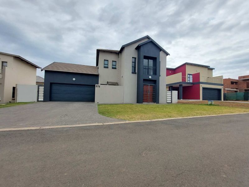 Modern double-story residential property featuring a paved driveway, double garage, and a front balcony with contemporary architectural finishes.