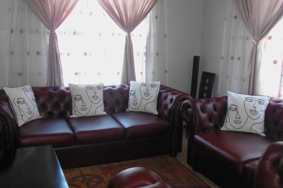 A living room area featuring windows with installed curtain rods.