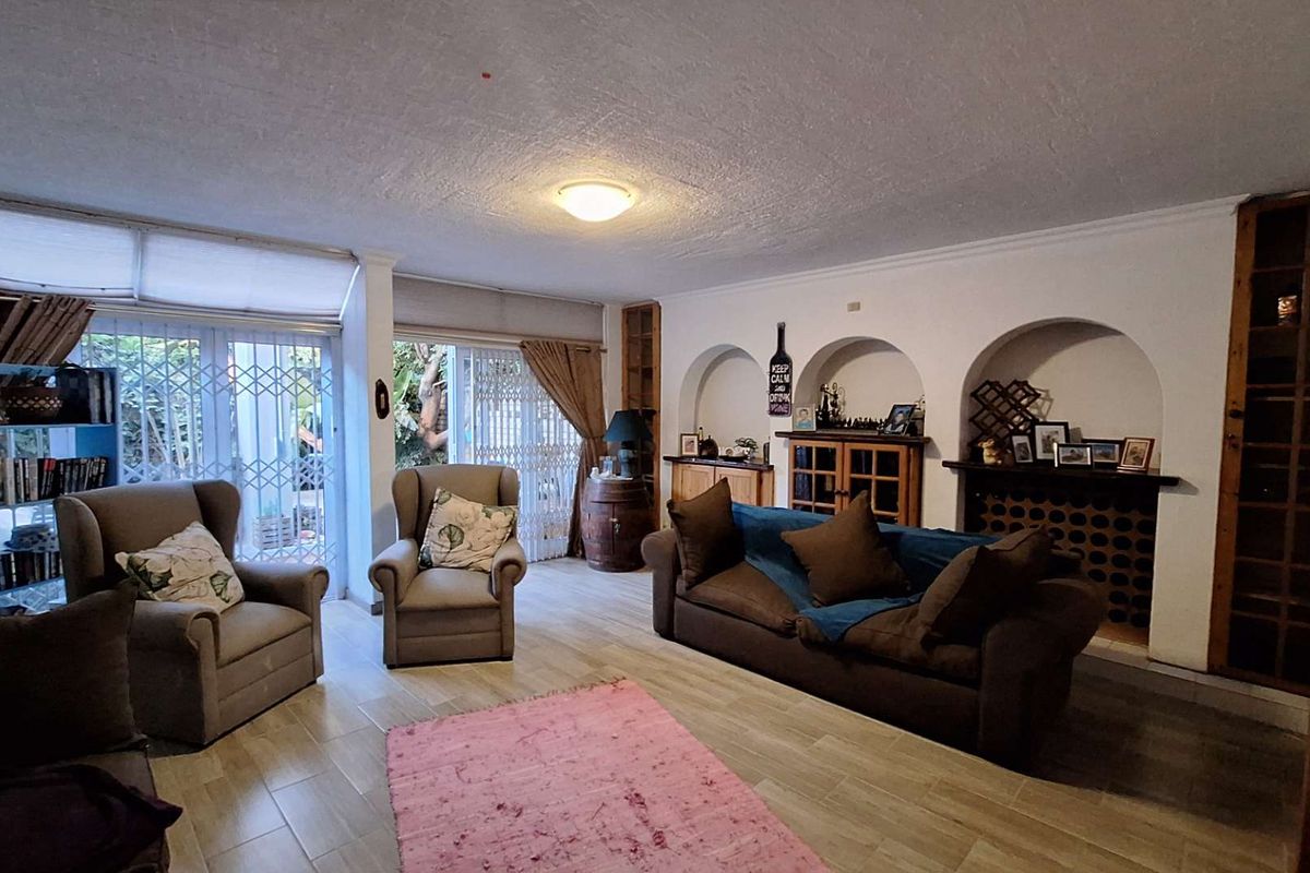 Spacious living room featuring tiled flooring, built-in arched wall niches, and sliding glass doors providing access to the outdoor area.
