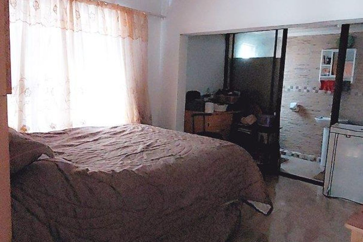 Bedroom featuring tiled flooring and direct access to an en-suite bathroom area.