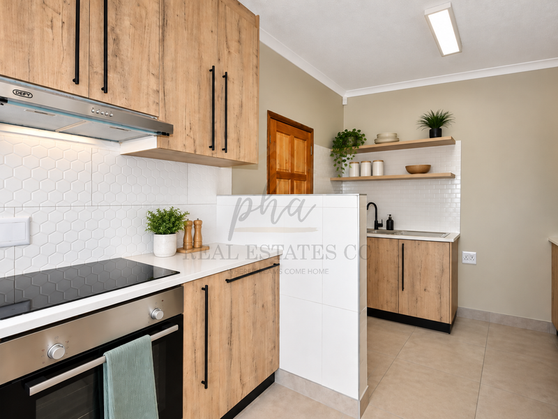 Modern kitchen featuring wood-look cabinetry, built-in oven and hob, white hexagonal tiled backsplash, and a functional scullery area with floating shelves.