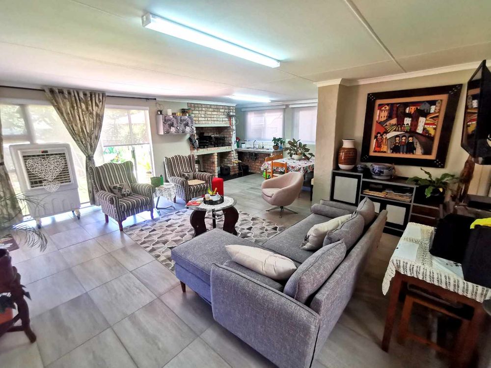 NEXT TO THE OPEN-PLAN KITCHEN WITH LOUNGE IS THIS INDOOR ENTERTAINMENT/FAMILY  ROOM WITH BUILT-IN BRAAI 