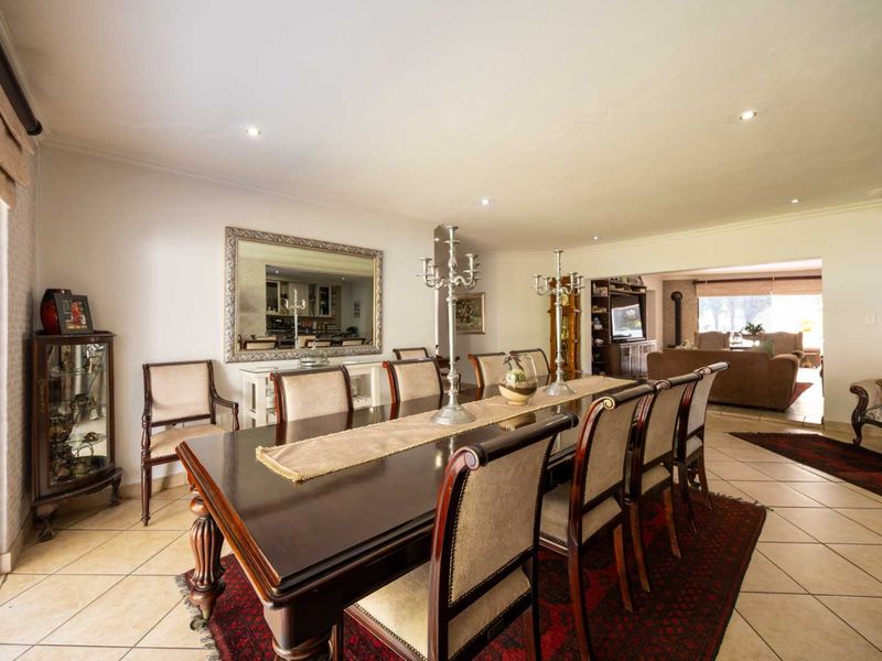 Spacious dining room featuring tiled flooring and recessed downlights, with an open-plan flow leading into the adjacent living area.