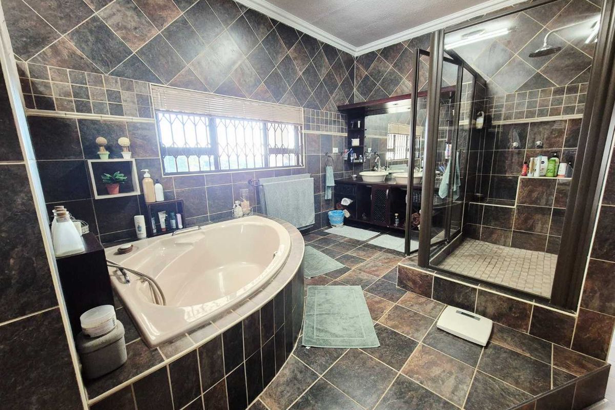 Spacious bathroom featuring a built-in corner soaking tub, a separate glass-enclosed shower, and a double vanity with integrated sinks.