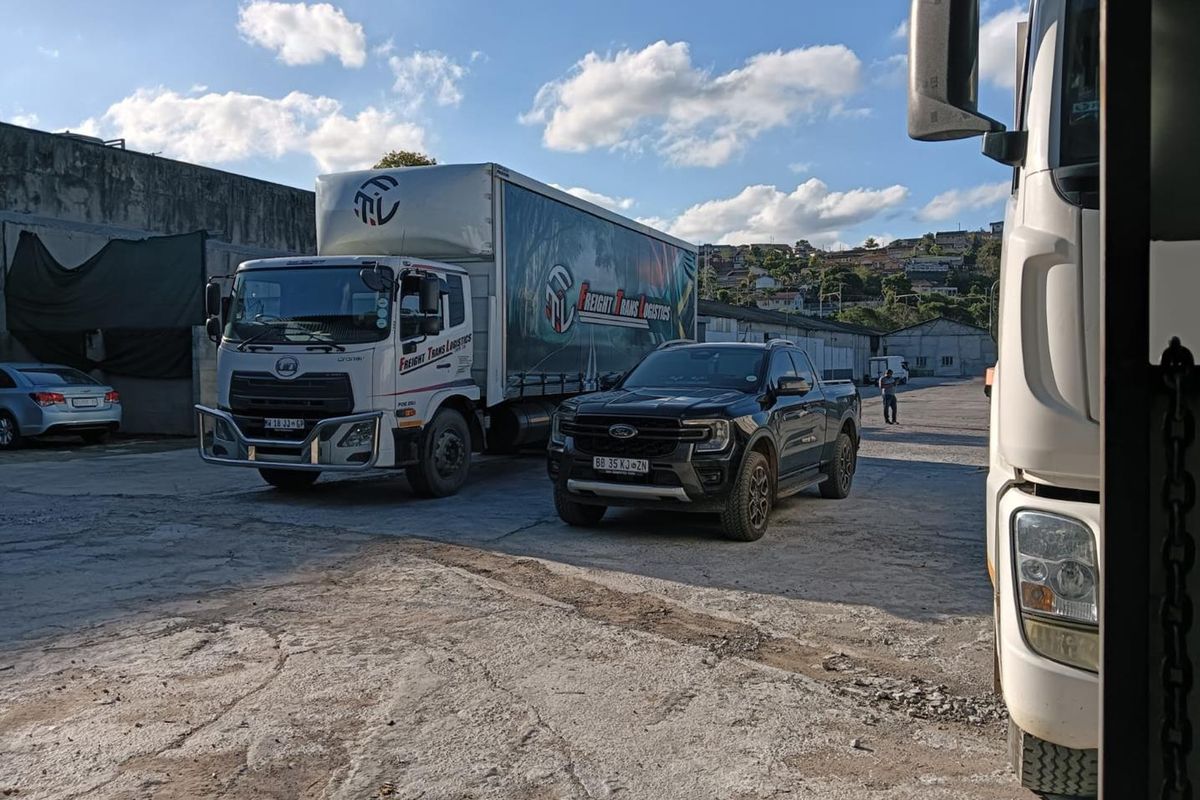 Industrial yard area featuring a large concrete surface and retaining wall, suitable for logistics and heavy vehicle operations.