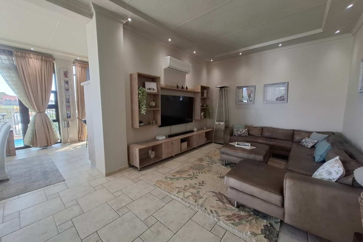 Spacious living room featuring tiled flooring, recessed ceiling lighting, a split-system air conditioner, and custom built-in media cabinetry.