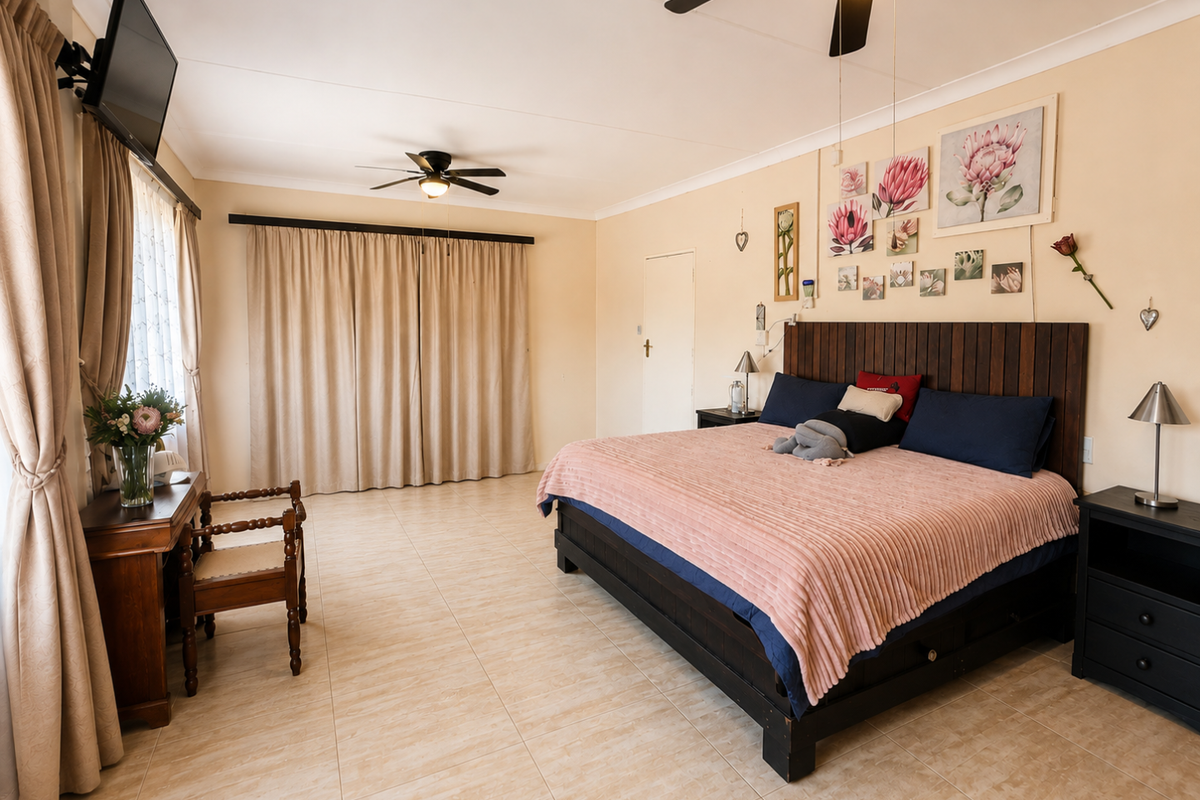 Spacious bedroom featuring neutral tiled flooring, dual ceiling fans, and large windows with floor-to-ceiling curtains, providing a bright and comfortable living space.