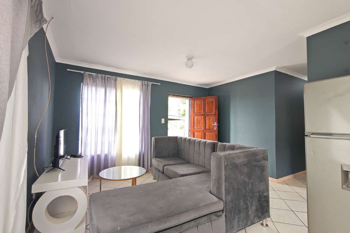 A living area featuring dark painted walls, tiled flooring, and direct access to an exterior door.