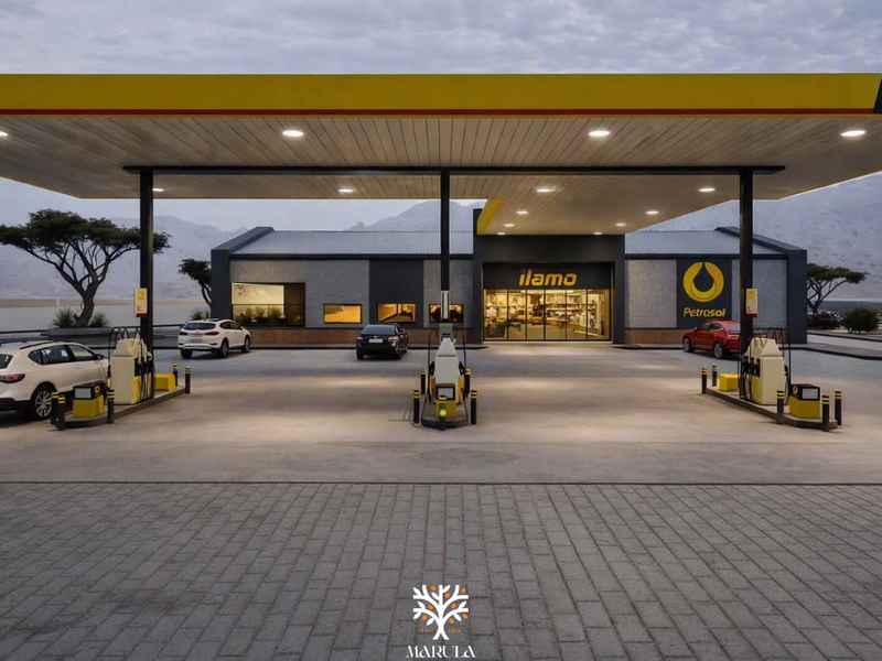 A modern, well-maintained commercial petrol station forecourt featuring a large canopy, multiple fuel pumps, and a paved driveway area.