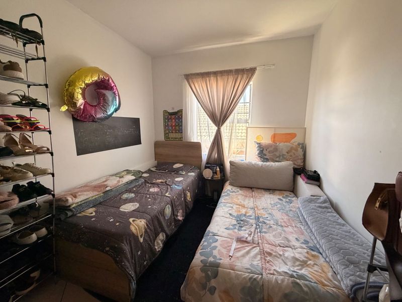 A compact bedroom featuring a window with natural light, suitable for a twin or single occupancy layout.