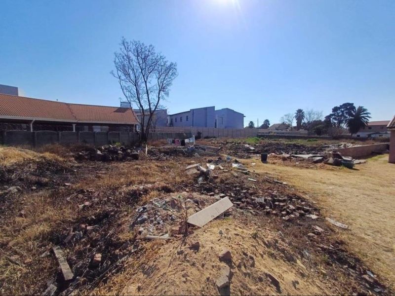 A large, undeveloped plot of land featuring perimeter walling and significant site debris, offering a blank canvas for future development.