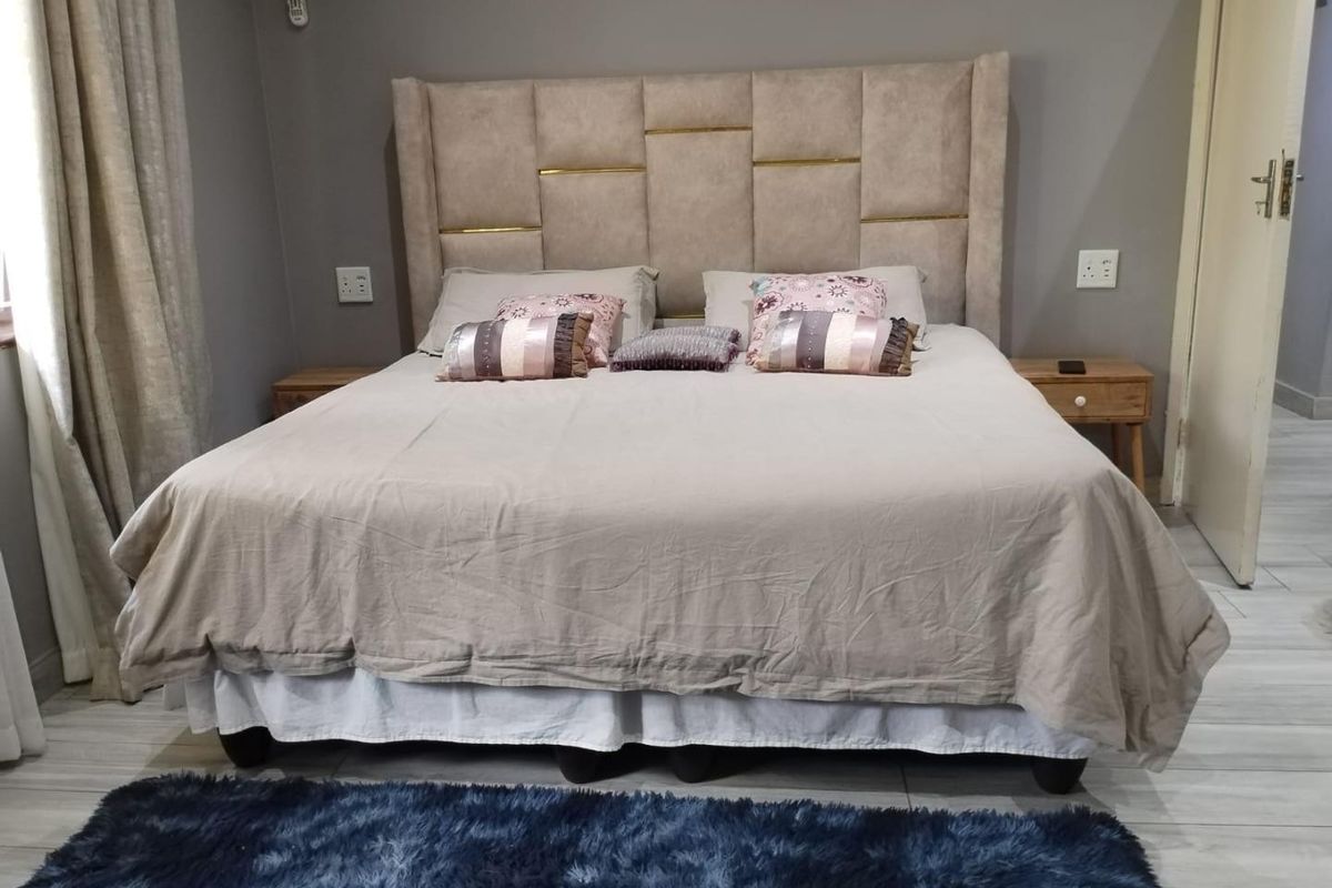 A well-maintained bedroom featuring neutral wall tones, tiled flooring, and integrated electrical fixtures.