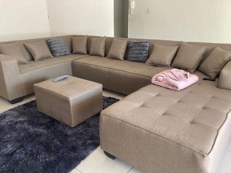 A living room area featuring neutral tiled flooring and a wall-mounted intercom system.