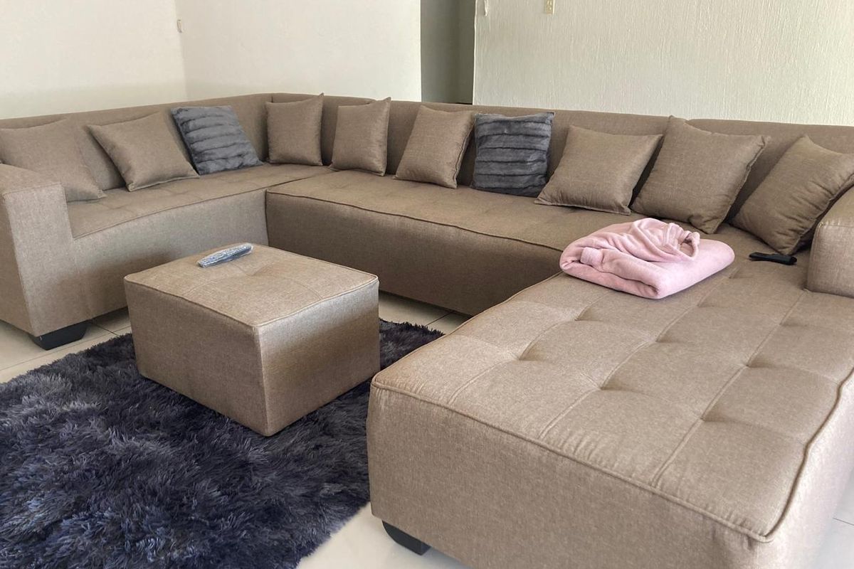 A living room area featuring neutral tiled flooring and a wall-mounted intercom system.