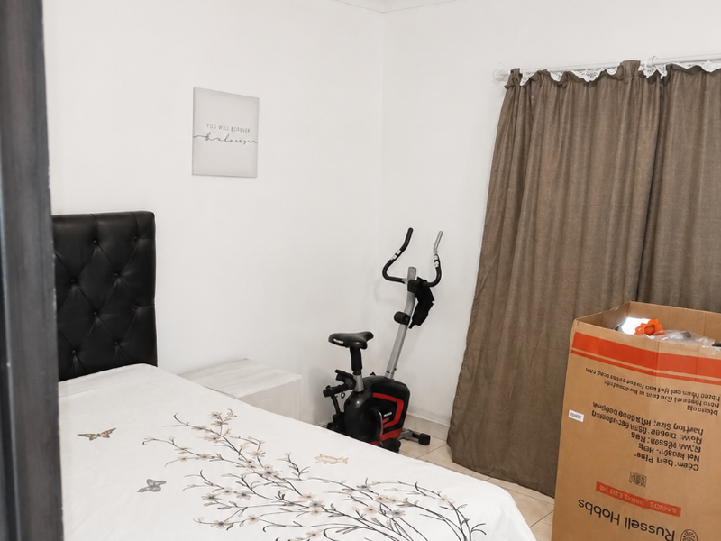 A bedroom featuring tiled flooring and neutral wall finishes, providing a functional space ready for personalization.