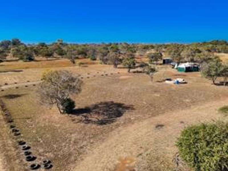 An aerial view of a large, open small holding property featuring expansive cleared land, native vegetation, and established boundary fencing.