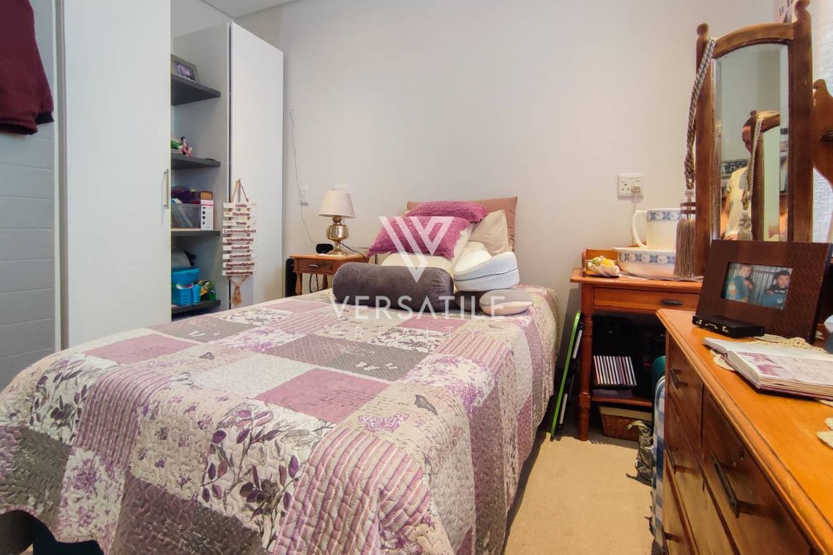 A functional bedroom featuring built-in white cabinetry and neutral carpeting, providing a comfortable living space within the retirement village.