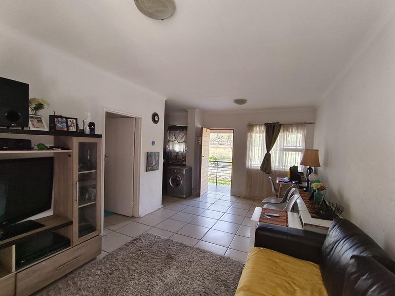 Open plan living area featuring tiled flooring and direct access to the exterior, providing a functional layout for daily living.