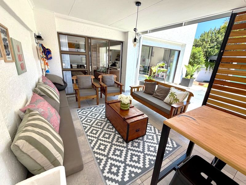 A covered outdoor patio area featuring tiled flooring and sliding glass doors that provide seamless access to the interior living space.