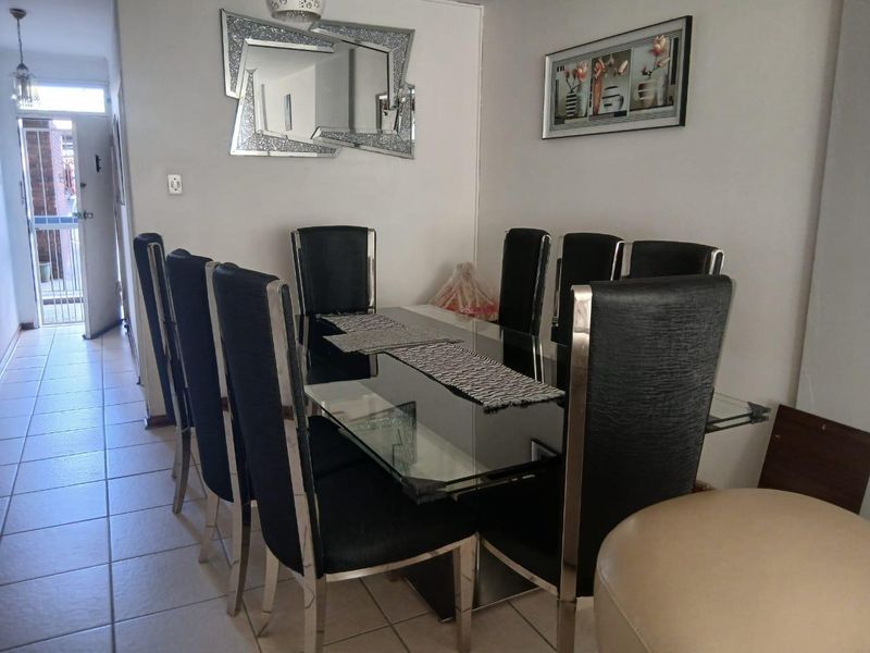 A dining area featuring ceramic floor tiles and direct access to an exterior security gate.